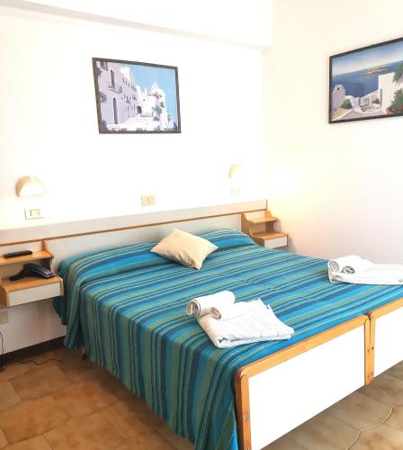 a bedroom with a bed with towels on it at Hotel Alcazar in Rimini