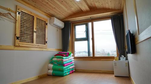 a room with a pile of pillows in front of a window at The Jeongga in Jeonju