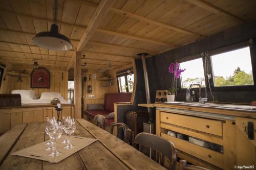 un comedor con una mesa con copas de vino. en BATEAU LE VENT DE TRAVERS en Saumur