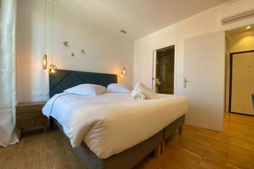 une chambre avec un grand lit blanc avec deux oreillers dans l'établissement C016-Magnifique appartement de standing au coeur du Suquet, à Cannes