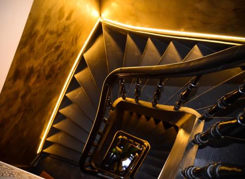 a gold stair case with a mirror on it at SLEEP INN - 1001 Nights Loft Citycenter with Balconyview in Antwerp