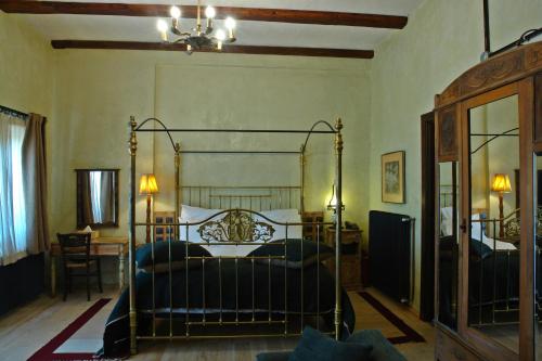 a bedroom with a bed with a wrought iron frame at Montanema Handmade Village in Platanákos