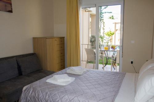 1 dormitorio con cama, sofá y balcón en Villa Nopigia Homeleader en Nopíyia