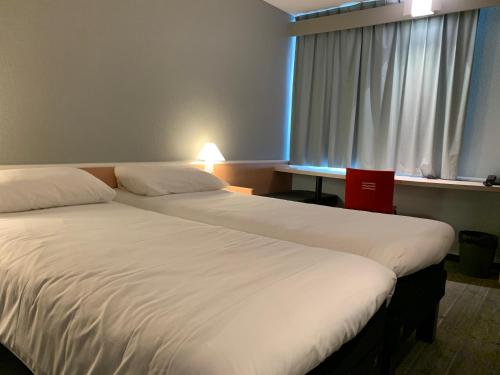 Una cama o camas en una habitación de Ibis Auray