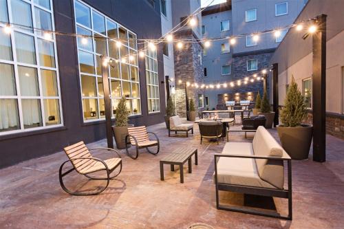 a patio with chairs and tables in a building with lights at Staybridge Suites - Denver North - Thornton by IHG in Thornton