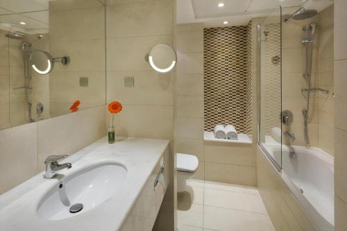 a bathroom with a sink and a shower and a toilet at Crowne Plaza Jeddah by IHG in Jeddah