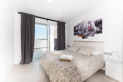 ein Schlafzimmer mit einem Bett und einem großen Fenster in der Unterkunft Casa Reina in Playa Blanca