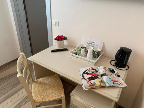 a desk with a table with a book and a chair at Affittacamere Il Borgo in Levanto