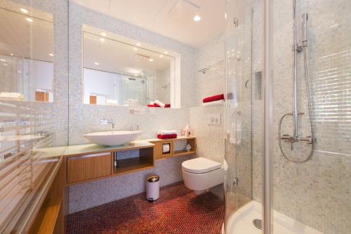 ein Bad mit einem Waschbecken, einem WC und einer Dusche in der Unterkunft Rosa Linde - Comfort Rooms in Wien