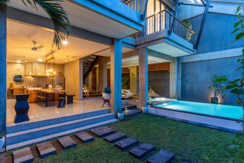 a house with a swimming pool in a yard at Omah Sabin Villa East in Canggu