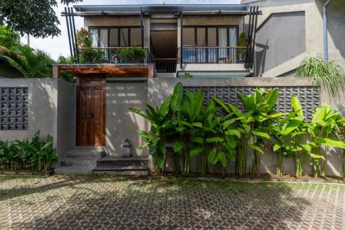 a house with a wooden door and a fence at Omah Sabin Villa East in Canggu