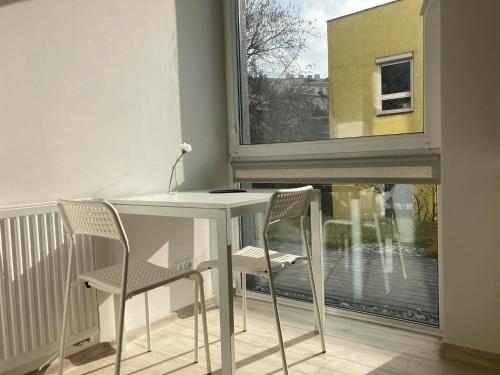 een tafel en twee stoelen in een kamer met een raam bij Apartament Prusa in Lublin