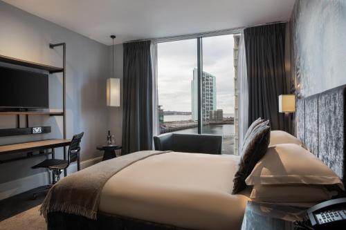 a hotel room with a bed and a large window at Malmaison Liverpool in Liverpool