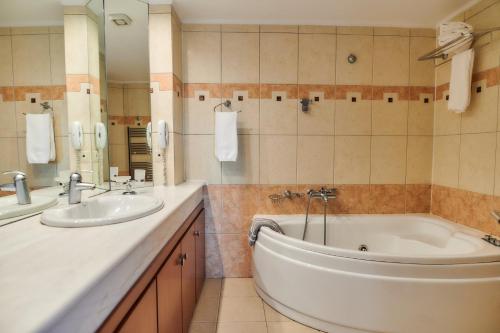 a bathroom with a tub and a sink at Nefeli Hotel in Alexandroupoli