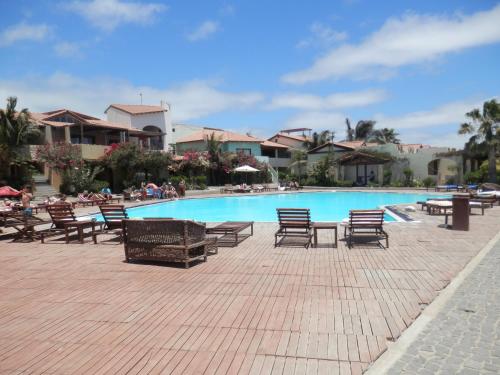 una piscina con sillas y gente sentada a su alrededor en Private Apartments 1 minute to the pool & beach Santa Maria #74B #86, en Santa Maria
