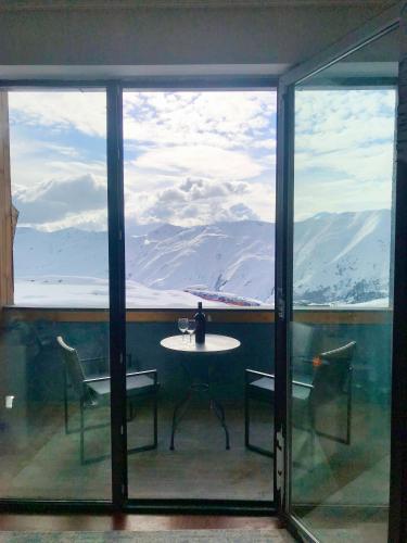 a table and chairs on a balcony with a view of mountains at GVC 4-room 421 New Gudauri in Gudauri