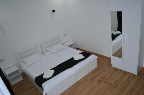 a white bed in a room with a mirror at White Hotel in K'obulet'i