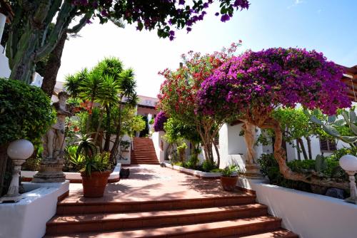 a walkway with flowers and trees and stairs at Gattopardo Park Hotel in Lipari