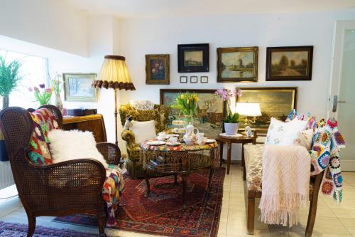 a living room with chairs and a table and a couch at Tante ALMA's Kölner Hotel in Cologne