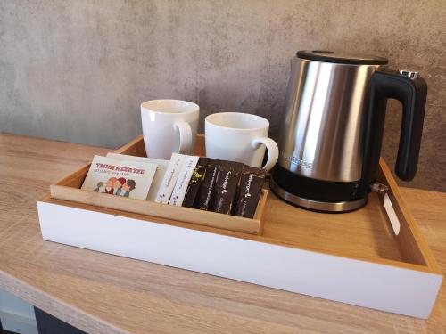 a tray with a coffee pot and books on a table at Hotel Graf Eberhard in Bad Urach