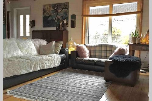 ein Wohnzimmer mit einem Sofa und einem Stuhl in der Unterkunft Norfolk Cabin in Kings Lynn