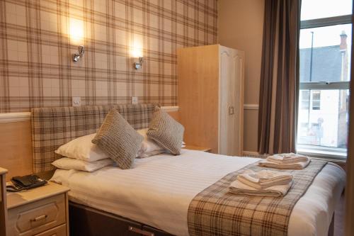 a bedroom with a bed with towels on it at Osborne Hotel in Newcastle upon Tyne