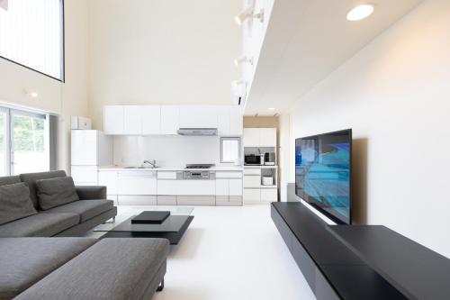 a living room with a couch and a tv at B BASE KOURI iSLAND in Kouri