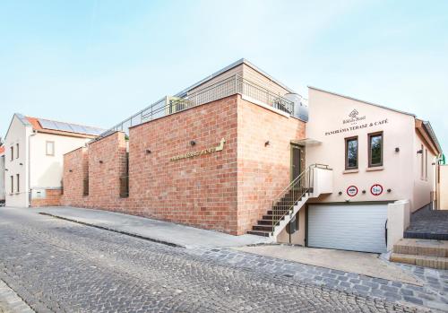 a brick building with a garage on a street at Bükkös Hotel & Spa in Szentendre
