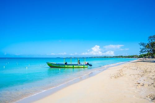 a boat sitting on the beach next to a beach at Shields Negril Villas in Negril