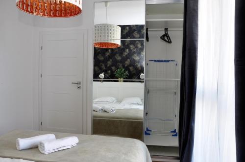 a bathroom with a sink, toilet and a door at Prudentia Apartments Kłobucka in Warsaw