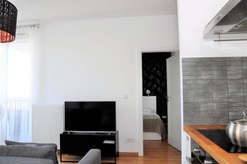 a living room filled with furniture and a tv at Prudentia Apartments Kłobucka in Warsaw