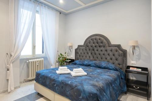 a bedroom with a blue bed with towels on it at Divo Apartments - Spanish Steps in Rome