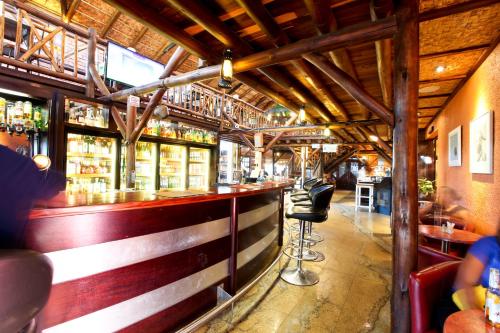 a bar in a restaurant with wooden beams at Roof of Africa Hotel in Windhoek