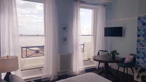 a room with a window with a view of the ocean at The Bank Hotel & Bistro in Hastings