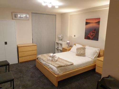 a small bedroom with a bed and a chair at Birmingham Diamond, 2 bedroom Apartment in Birmingham