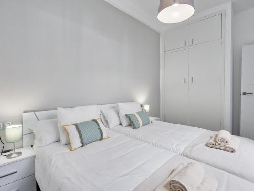 2 łóżka w białym pokoju z białymi ścianami w obiekcie Sur Suites El Carmen w mieście Fuengirola