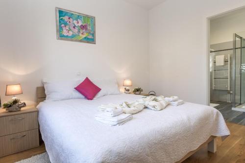 sypialnia z białym łóżkiem i ręcznikami na nim w obiekcie Beachfront Holiday House Kaliope w mieście Brgulje