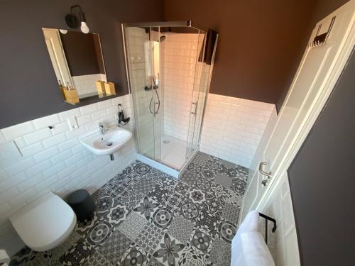 a bathroom with a shower and a toilet and a sink at Aparthotel Charlotten in Hannover