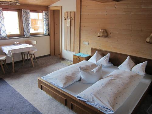 een slaapkamer met een bed met kussens en een tafel bij Gästehaus Valentina in Mayrhofen