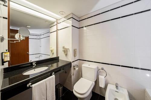 La salle de bains est pourvue de toilettes et d'un lavabo. dans l'établissement Hotel do Canal, à Horta