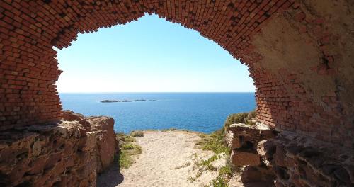a view of the ocean through a brick archway at B&B Del Viale in Bacu Abis
