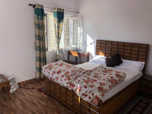 een slaapkamer met een groot bed en een rode deken bij White house in Nainital in Bhīm Tāl