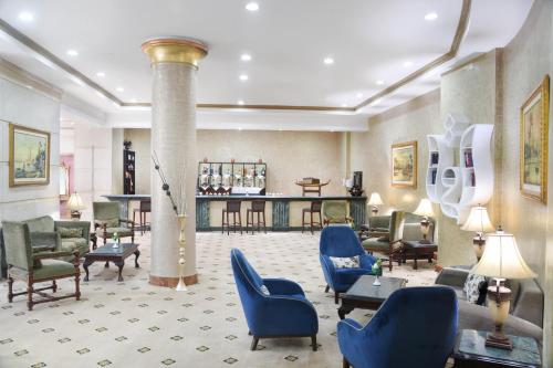 a lobby with blue chairs and a column at Tolip Aswan Hotel in Aswan