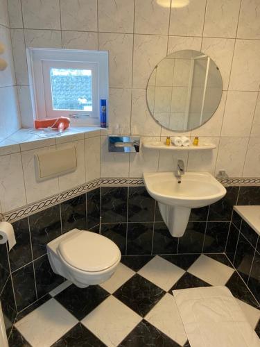 W łazience znajduje się umywalka, toaleta i lustro. w obiekcie Appartement Aqua w mieście Oude Wetering