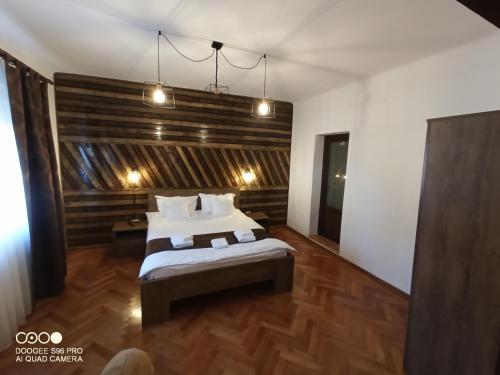 a bedroom with a bed with a wooden wall at Casa Evanti in Sibiu