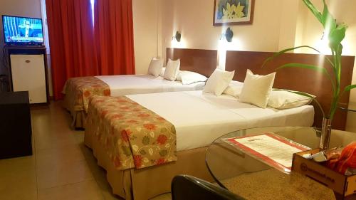 Habitación de hotel con 2 camas y mesa en Hotel Amalfi en Asunción