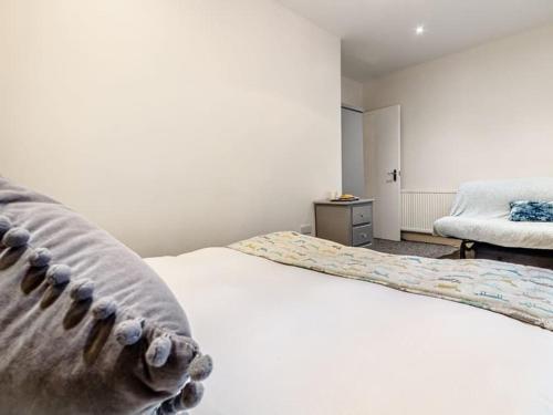a bedroom with a white bed and a chair at Golden Crown exclusive use spa venue in Tarbolton
