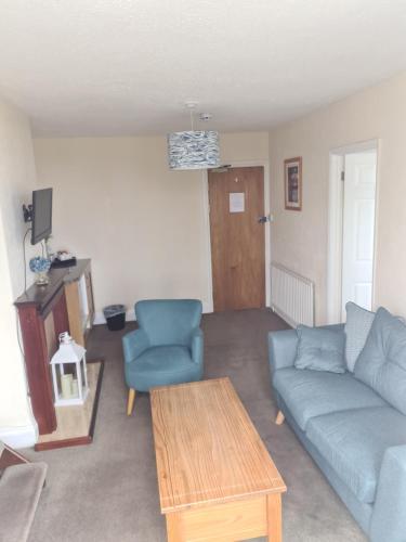 a living room with a blue couch and a table at The Trelinda Guest House in Newquay