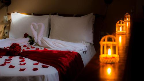 a bedroom with a bed with a candle and a bird cage at Pousada dos Ingleses in Bombinhas
