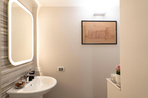 een witte badkamer met een wastafel en een spiegel bij Casa Magò in Catania